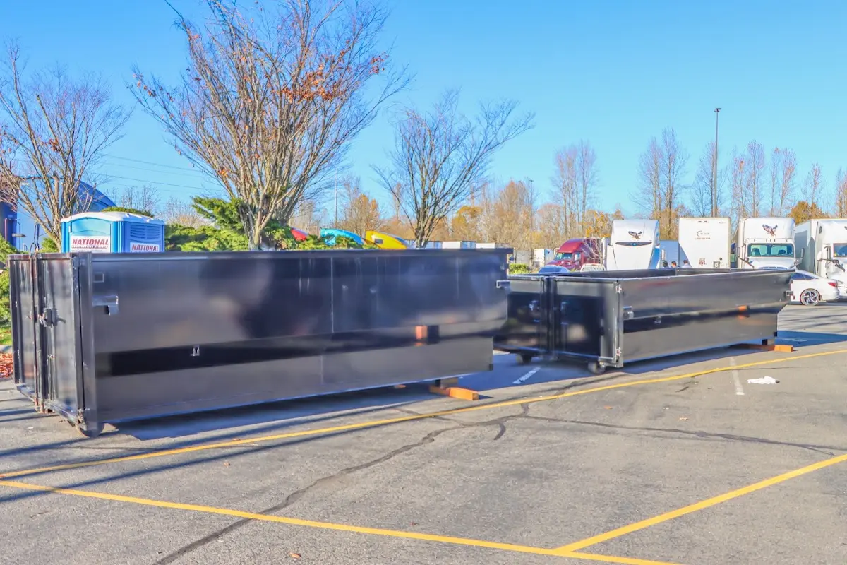 Professional dumpster rental service with roll-off container on residential driveway in Riverbank